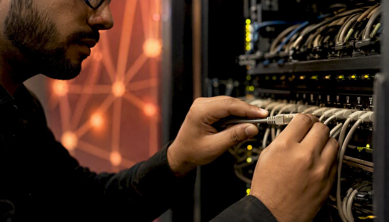 1786956046050_Hands-connecting-network-cable-in-server-room | Total Cyber Solutions Hands connecting network cable in server room