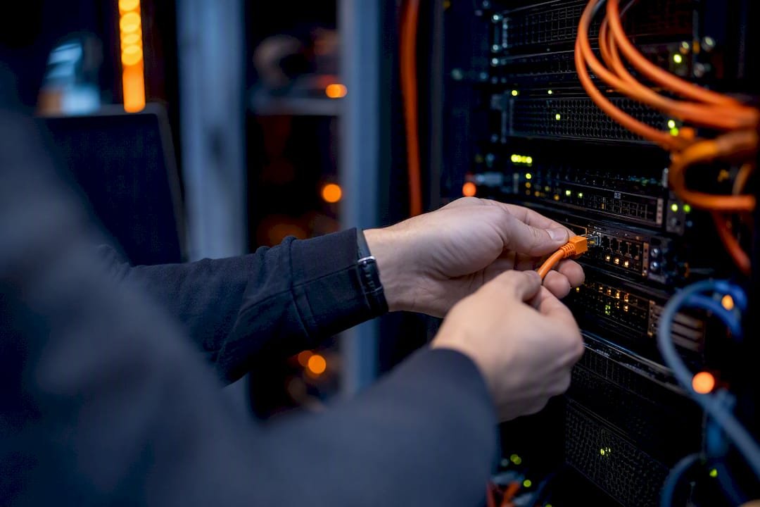 1787539616259_Hands-connecting-cable-in-secure-server-rack | Total Cyber Solutions Hands connecting cable in secure server rack